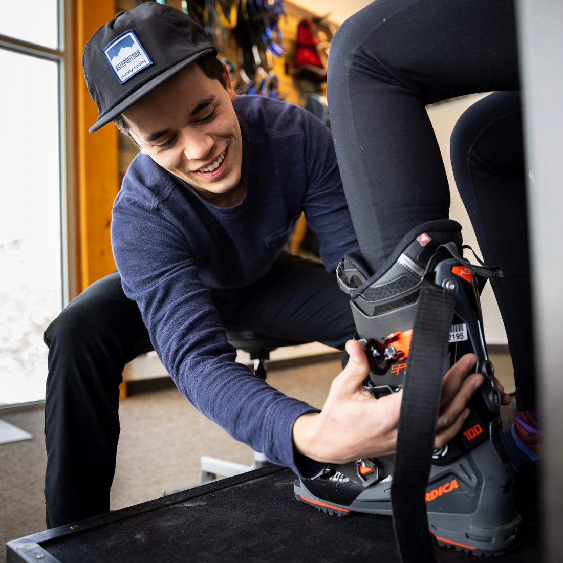 Christy Sports specialist fitting a customer’s ski boot