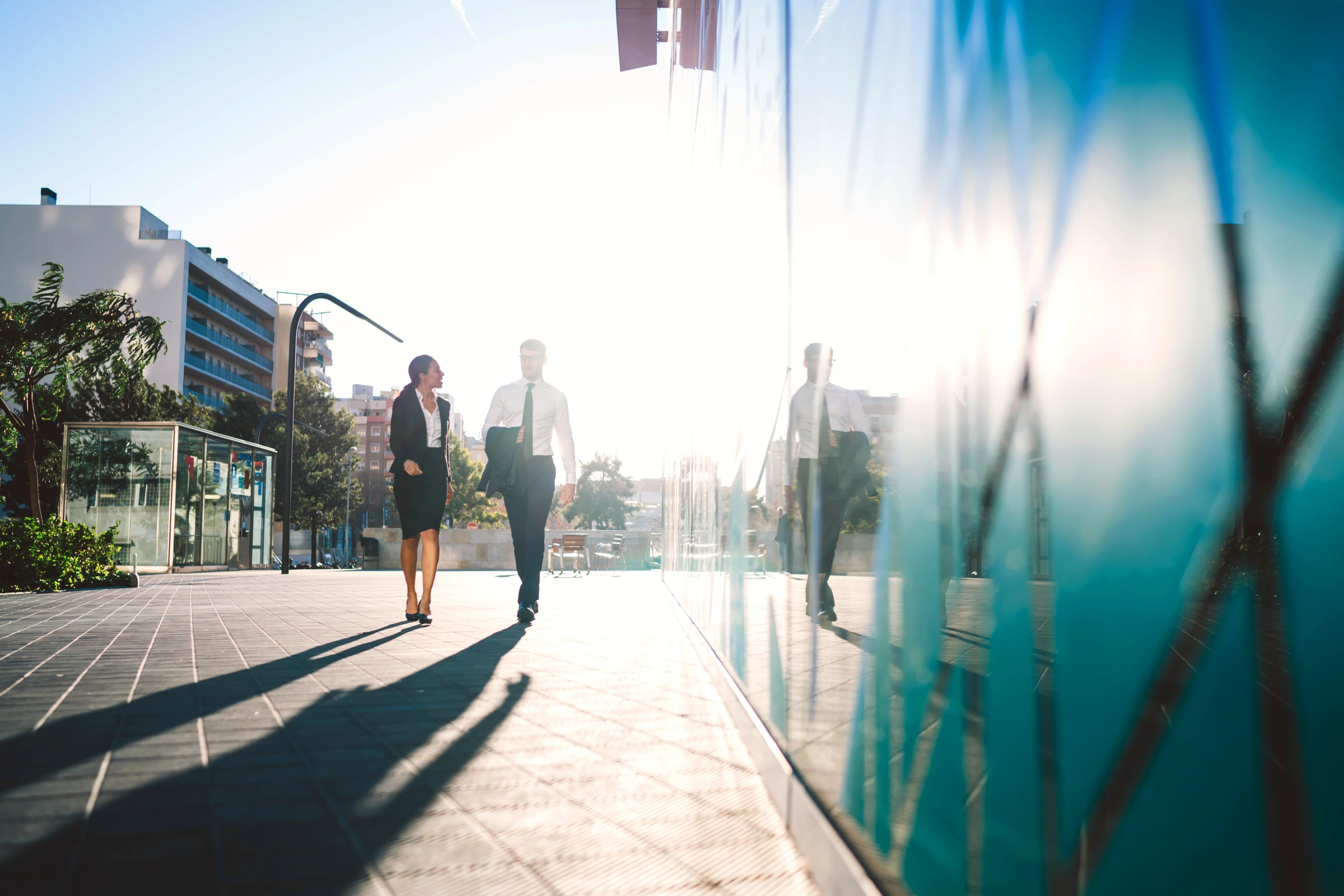 Two business professionals walking beside a modern office building
