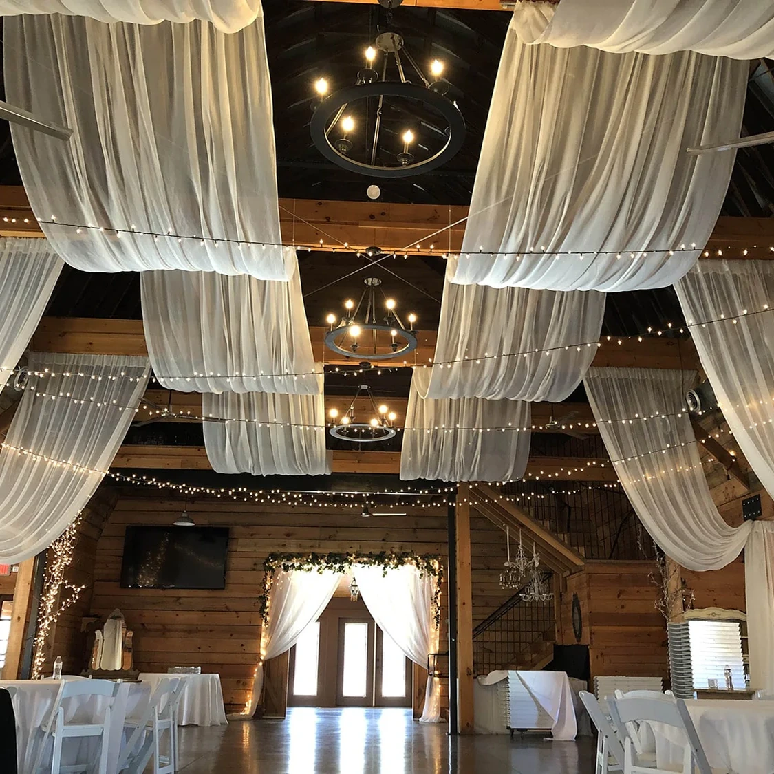 White event drapery and chandeliers installed in a reception venue