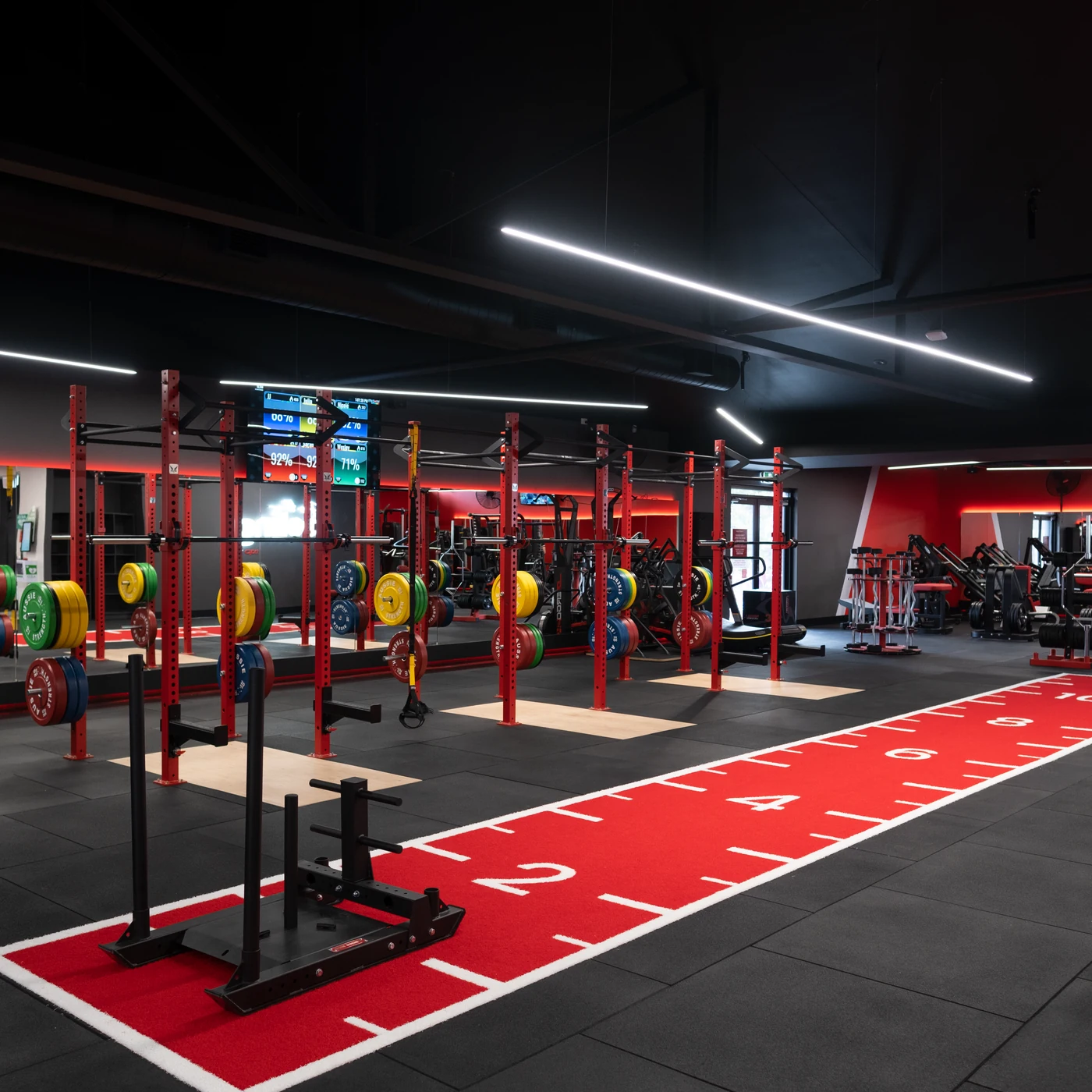Snap Fitness gym floor with strength equipment and a red training lane