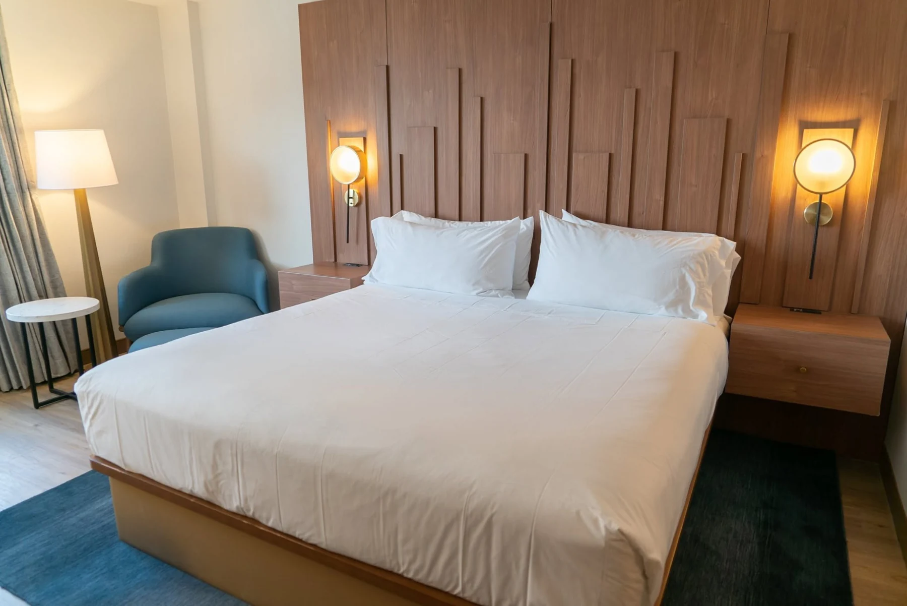 Furnished bedroom with upholstered bed and bedside lighting