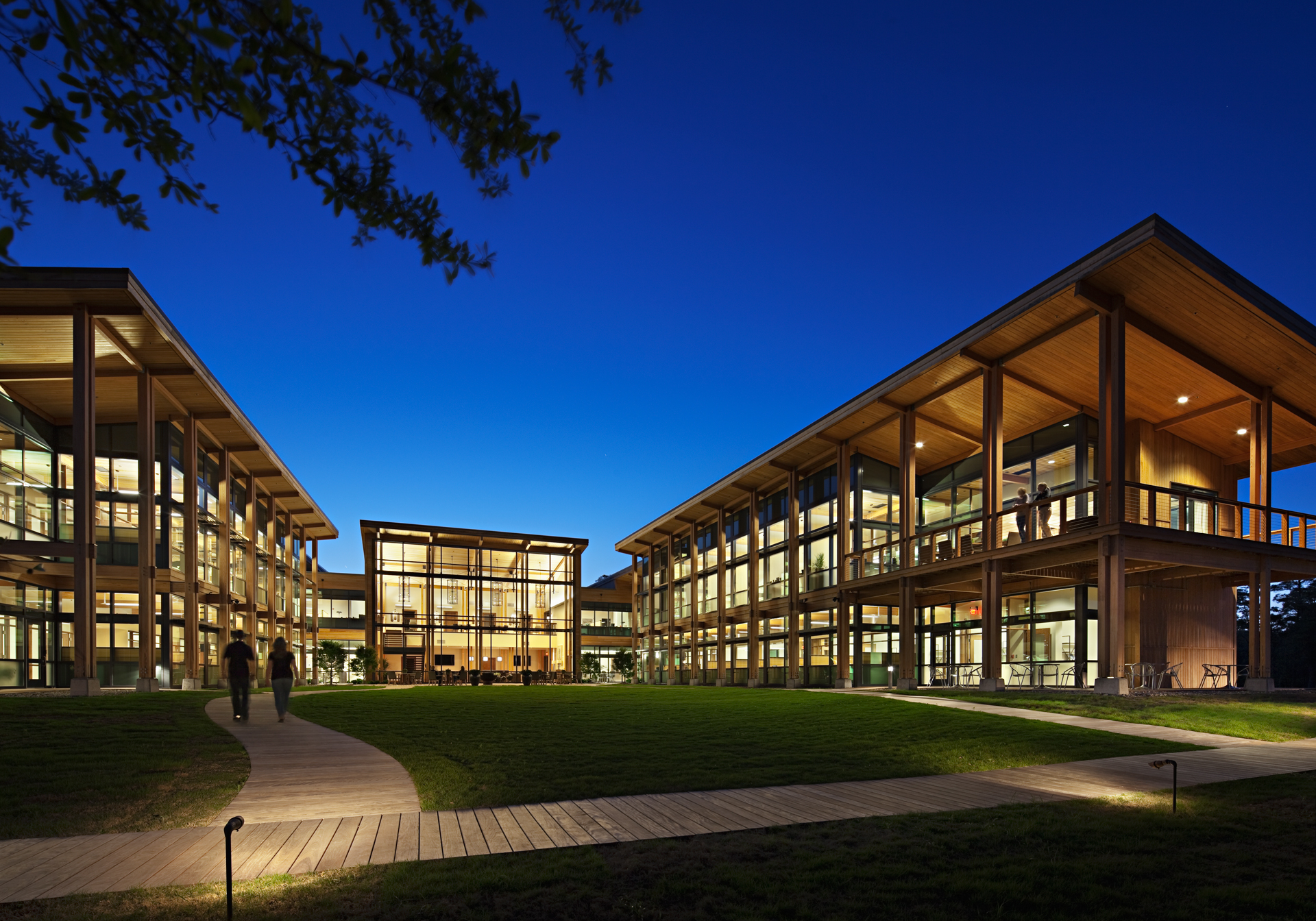 Illuminated glass-fronted campus buildings at dusk